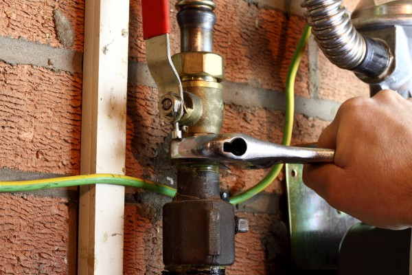 Plumber connecting a copper gas pipe in a home